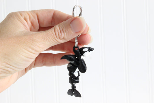 Alternate view of the 3D-printed black-and-white orca keychain showing its sculpted details and segmented design.