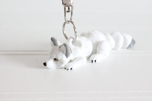 3D-printed white Arctic fox keychain with a silver swivel quick-clip on a white background.