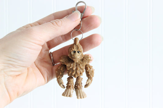 3D-printed brown Bigfoot keychain with a silver swivel quick-clip on a white background.