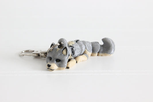 Alternate view of the 3D-printed gray wolf keychain to show its colors and silver swivel clip.