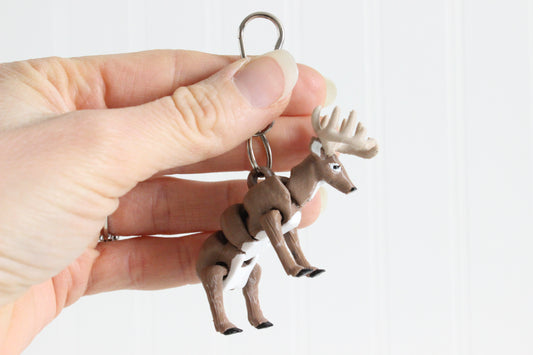 3D-printed brown buck with antlers keychain with a silver swivel quick-clip on a white background.