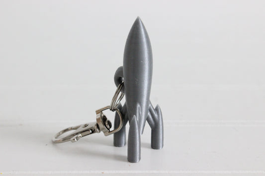 3D-printed rocket keychain with a silver swivel quick-clip on a white background.
