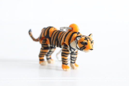 3D-printed orange, black, and white tiger keychain with a silver swivel quick-clip on a white background.