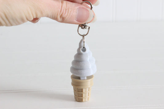 Alternate view of the 3D-printed cookies-and-cream soft-serve ice cream cone keychain showing its shape, color, and key-ring attachment.