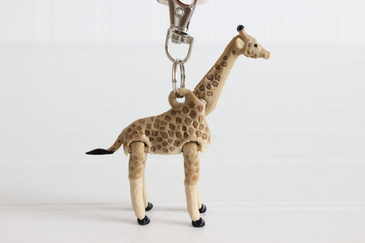 3D-printed tan giraffe with brown spots keychain with a silver swivel quick-clip on a white background.