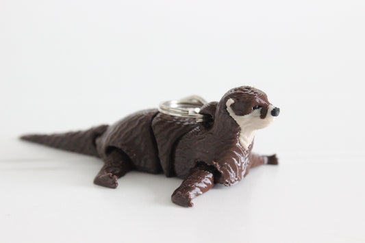 Alternate view of the 3D-printed river otter keychain showing its sculpted details and segmented design.