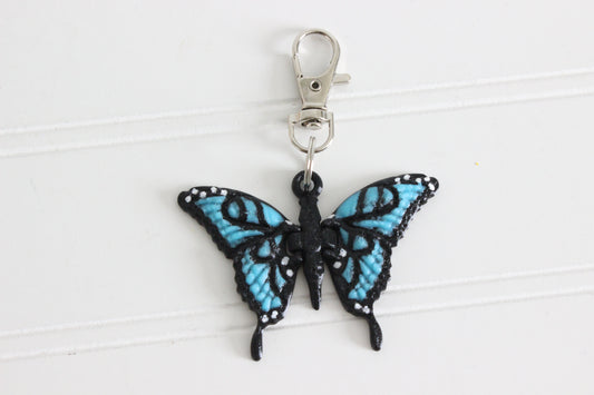 3D-printed blue butterfly keychain with a silver swivel quick-clip on a white background.