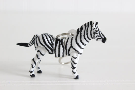 3D-printed black-and-white zebra keychain with a silver swivel quick-clip on a white background.