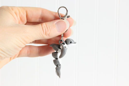Alternate view of the 3D-printed gray dolphin keychain showing its sculpted details and segmented design.