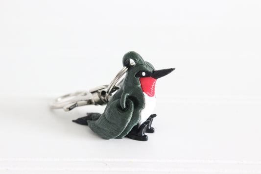 3D-printed green hummingbird keychain with a silver swivel quick-clip on a white background.