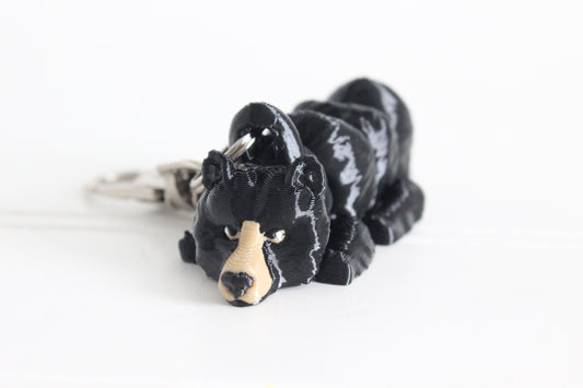 3D-printed black bear keychain with a silver swivel quick-clip on a white background.