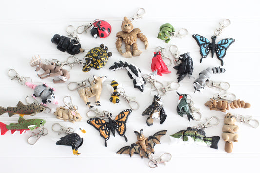 Collection of Mighty Horizons 3D printed animal keychains, including birds, butterflies, fish, mammals, reptiles, and insects, displayed on a white background.