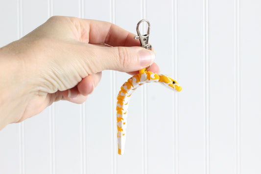 Yellow Burmese Python held in a person's hand for scale