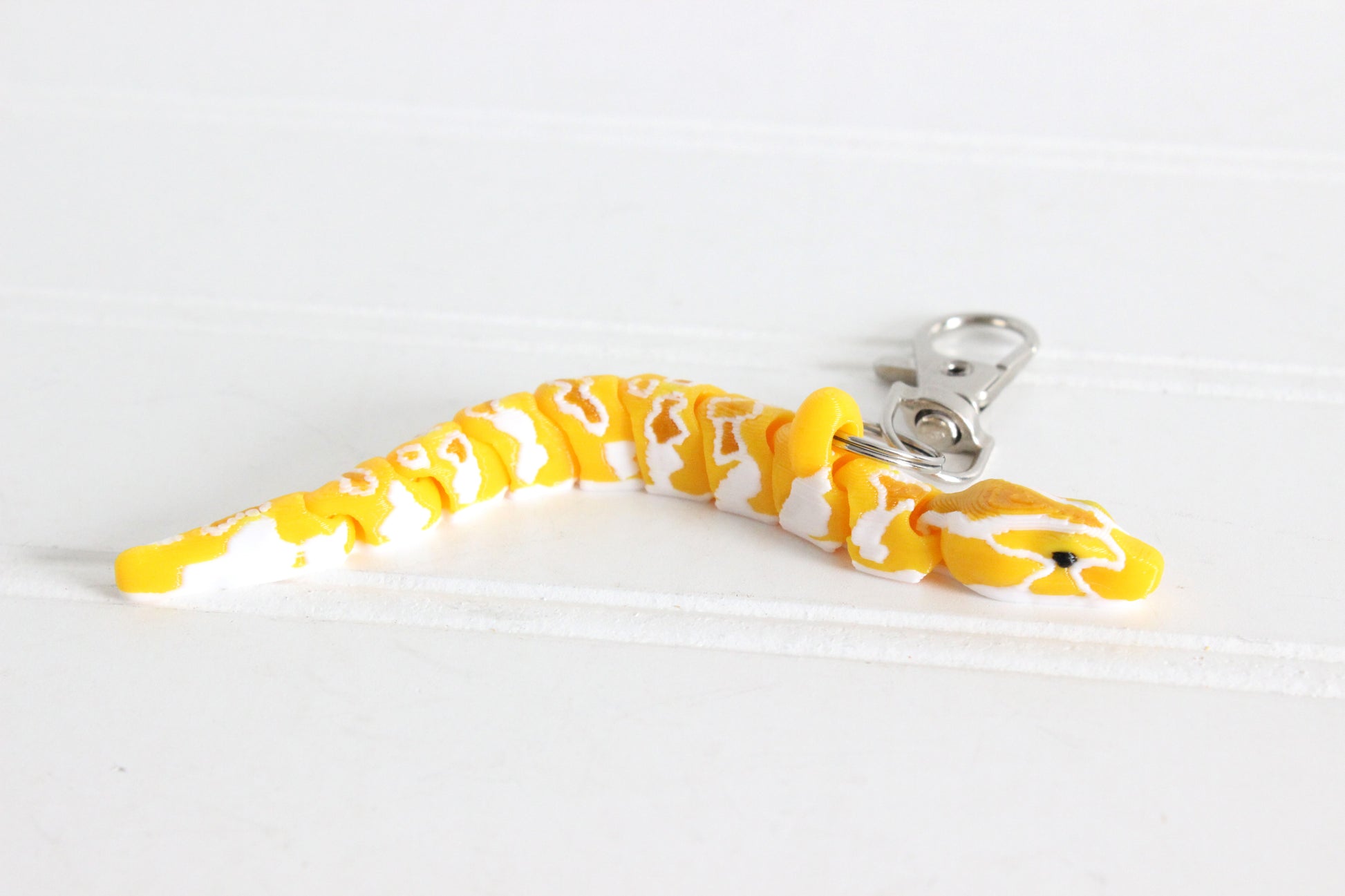 Yellow Burmese Python with a sliver Quick-Clip on a white background