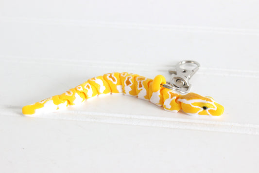 Yellow Burmese Python with a sliver Quick-Clip on a white background